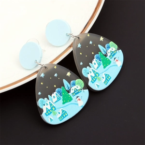 Détail du motif bonhomme de neige et sapin de Noël sur boucles d'oreilles