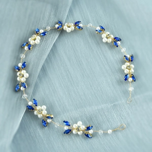 Detail of bridal hair vine with white pearls and blue crystals on golden wire
