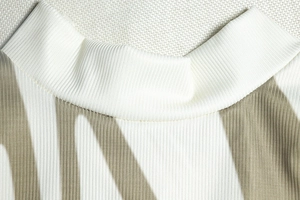 Detail of the high-neckline on a slim sleeveless dress with ribbed knit texture