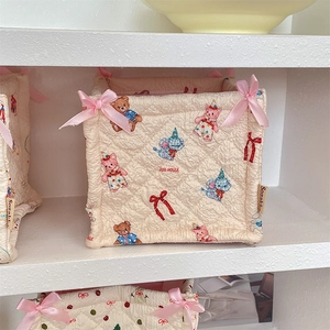 Detail of quilted fabric storage basket with cute cartoon bear and bow decorations