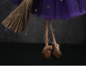 Macro view of Halloween witch broom with rusty metal bells and purple star gauze skirt