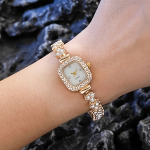 Montre quartz carrée dorée de luxe avec strass sur le bracelet portée au poignet