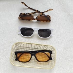 Three pairs of retro cat eye sunglasses in tortoiseshell, white and black frames