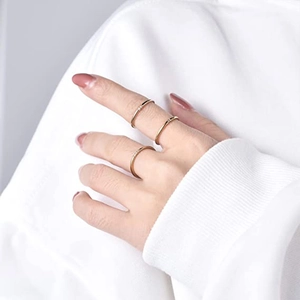 Close-up of three minimalist stacked gold rings with micro-set zircons on hand