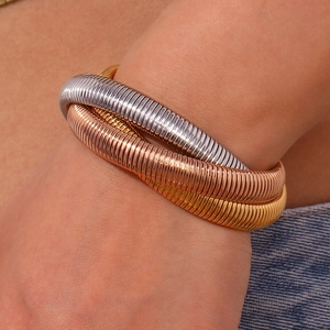 Detailed close-up of flexible three-tone Tubogas snake chain bracelet in 18K gold finish