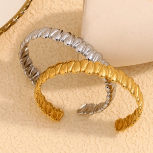Macro shot of 18K gold and silver plated stainless steel teardrop twisted bangles
