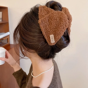 Detail van de bruine teddy pluche haarklem met berenlabel voor knotkapsels