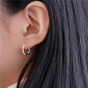 Macro side view of minimal 925 sterling silver hoop earrings with white zircon accents