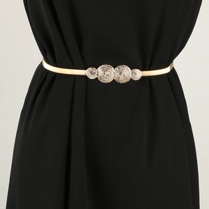 Elastic gold metal waist chain with four vintage embossed rings on a black dress