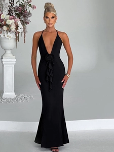 Close-up of elegant 3D floral accent and ruffled details on a black halter evening gown