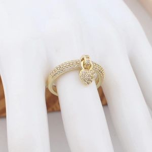 Close-up of golden heart pendant ring with micro-paved crystal zircons on a hand model