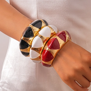Detailed view of layered geometric metal bangles in black, white, and red enamel finishes