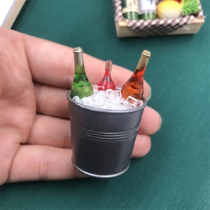 Miniature ice bucket with wine bottles shown in hand to demonstrate small scale and detail