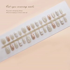 White and champagne cat eye press-on nails set with gold lines and glitter accents