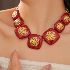 Dettaglio di una collana girocollo vintage in smalto rosso con filigrana dorata fine