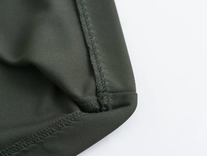 Detail of dark green midi dress showing high-quality double stitching and fabric texture