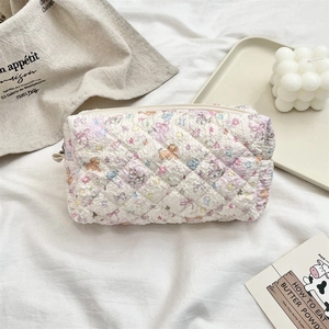 Detail of quilted cartoon puppy pouch with soft texture and floral patterns