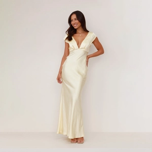 Detailed view of pale yellow satin dress featuring deep V-neck and silky smooth fabric texture