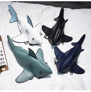 Detail view of four shark-shaped PU leather mini crossbody bags in assorted colors