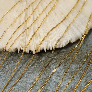 Macro shot of 18K gold plated textured chains resting on white coral decoration