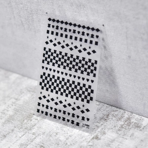 Detail of ultra-thin nail stickers with black checkerboard, heart and star patterns