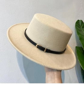 Detail of beige felt boater hat with black leather belt buckle and fine wool texture