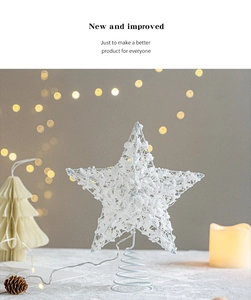Close-up of white wire star tree topper with battery pack and spring base on table