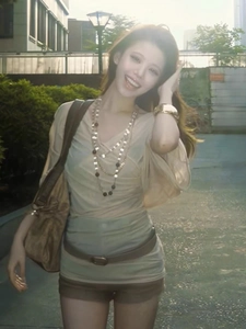 Detailed outdoor shot of model wearing layered vintage crystal beaded necklace with gold bracelets