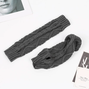 Detail of grey cable-knit arm warmers with thumb holes and classic diamond pattern
