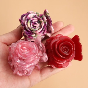 Three acrylic flower hair claws in purple marble, pink marble, and solid red finish