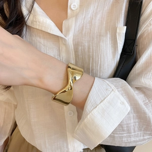 Macro view of gold irregular geometric cuff bracelet with polished mirror surface finish