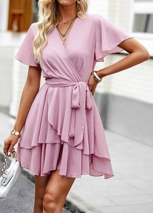 Vue détaillée de la robe rose à col en V avec des volants et un design noué à la taille