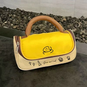 Close-up of portable cylindrical makeup bag with cartoon print and brown leather handle