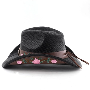 Detail of embroidered pink flowers and leather band on a black woven cowboy hat