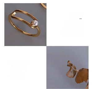 Macro detail of 18K gold plated titanium steel ring featuring an elegant white faux pearl