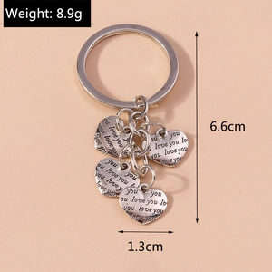 Detailed view of silver heart keychain with five love you engraved heart pendants