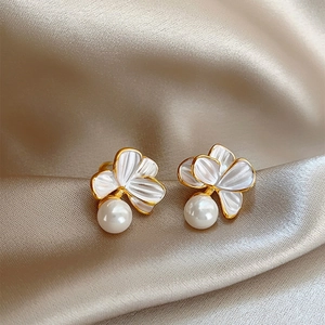 Boucles d'oreilles fleur blanche bordure dorée et perle sur tissu de soie champagne