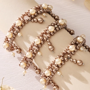 Elegant layered white pearl bracelet with champagne gold beads on a display stand