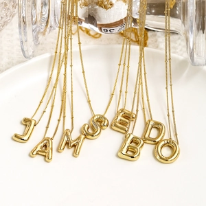 Gold balloon-style initial pendant necklace with shiny polished finish on beaded chain