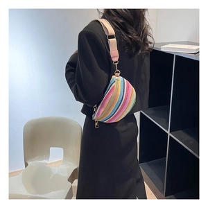 Close-up of bohemian rainbow woven waist bag with wide strap and gold zipper details