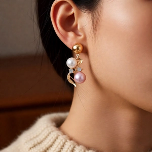 Detailed close-up of French vintage gold leaf earrings with white and pink pearls on a model