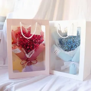 White gift bag with transparent window featuring dried gypsophila flower bouquet with lace