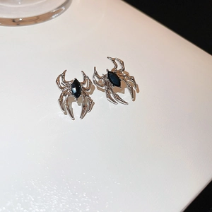 Macro shot of spider stud earrings featuring silver metal and black marquise gemstones