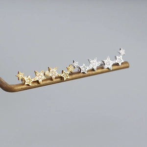 Detail view of gold and silver S925 sterling silver star-shaped diamond stud earrings