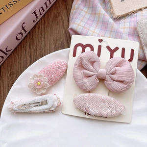 Pink fabric bow hair clips set for girls including floral accents and textured oval pins