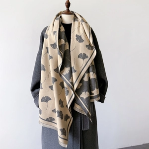 Detail of beige and grey cashmere-like scarf with ginkgo leaf pattern and short fringes