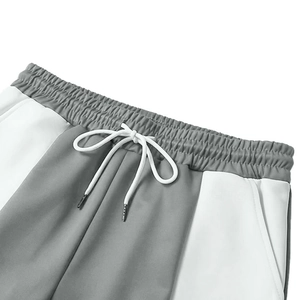 Dettaglio dell'elastico in vita con coulisse bianca su pantaloni sportivi grigi