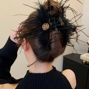 Détail d'une pince à cheveux en plumes noires avec accent métallique pour coiffure
