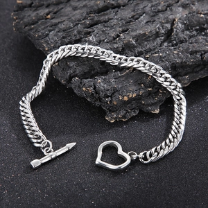 Silver 8mm Cuban chain bracelet featuring a unique heart-shaped toggle clasp on charcoal
