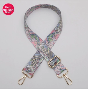 Detail of adjustable bohemian printed bag strap with shiny gold metal hardware
